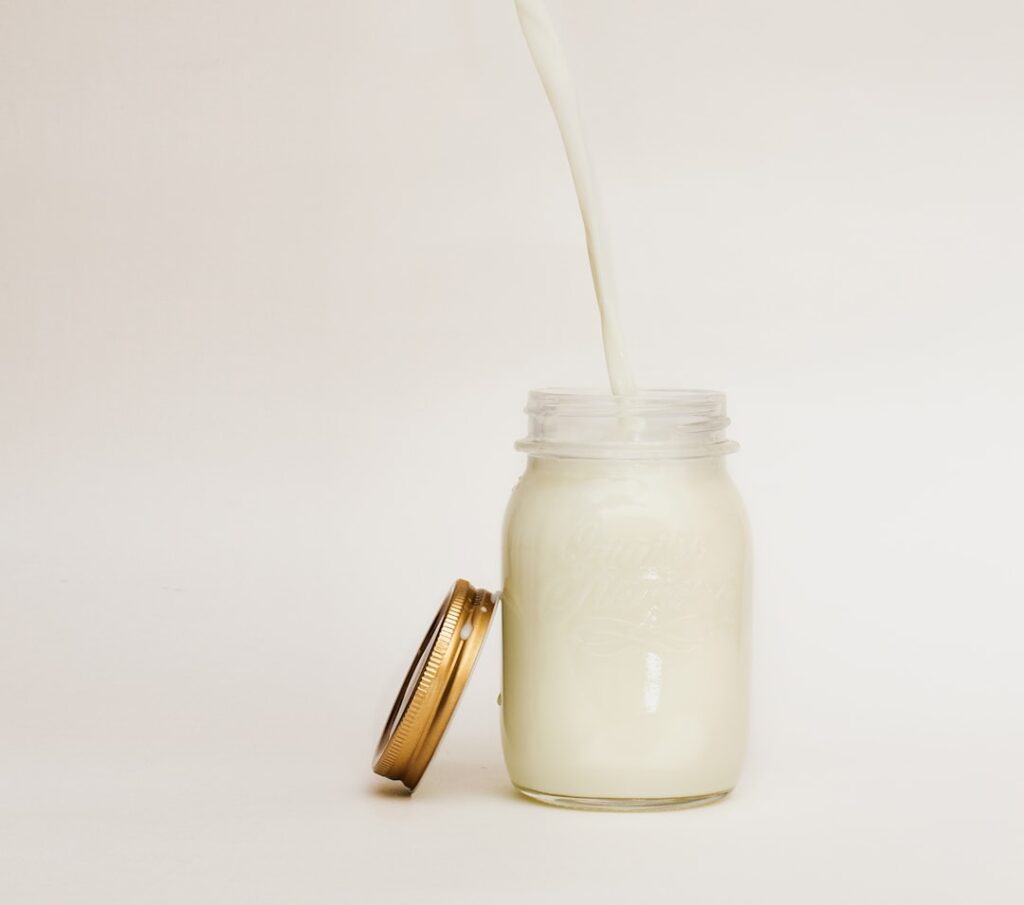 Fresh milk being poured into a mason jar, the starting point for both kefir and yogurt fermentation