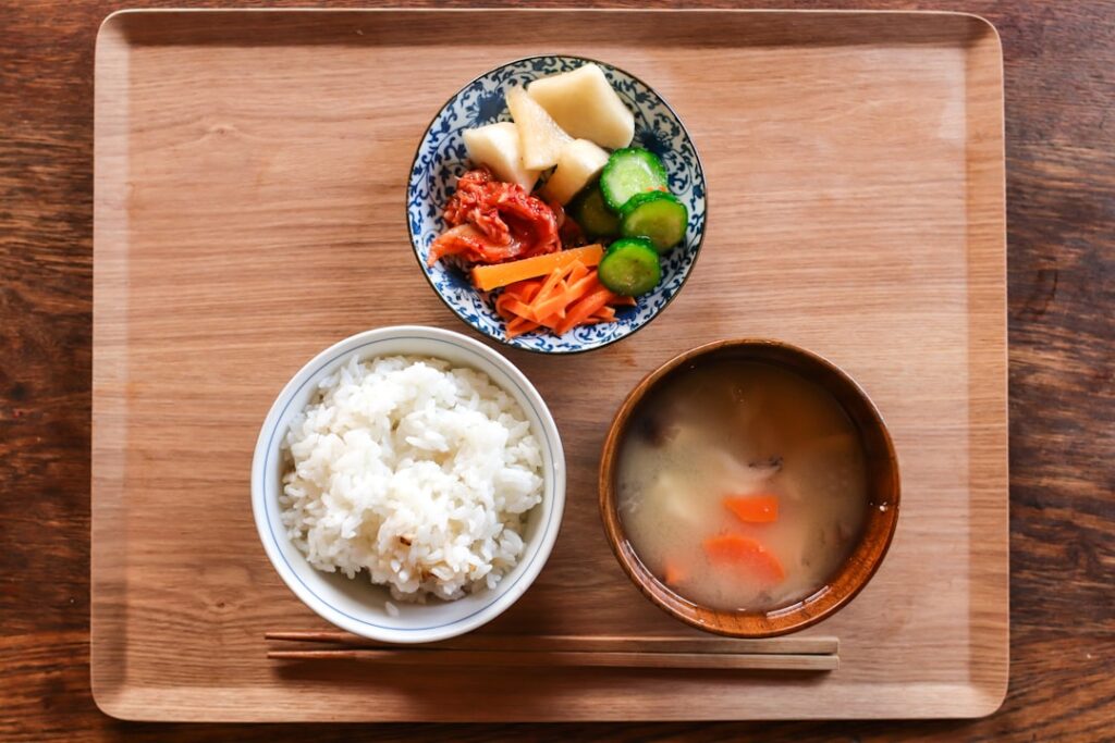 A traditional Japanese breakfast tray with rice, miso soup, and small side dishes — the classic context for eating natto