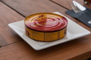 A can of surströmming fermented herring on a white plate