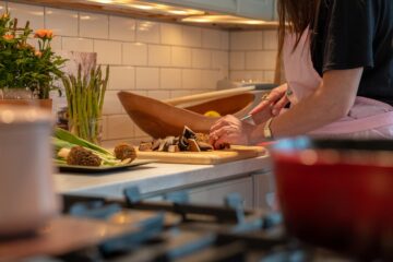 Woman chopping vegetables in a warm home kitchen, illustrating the cooking context for onion chemistry