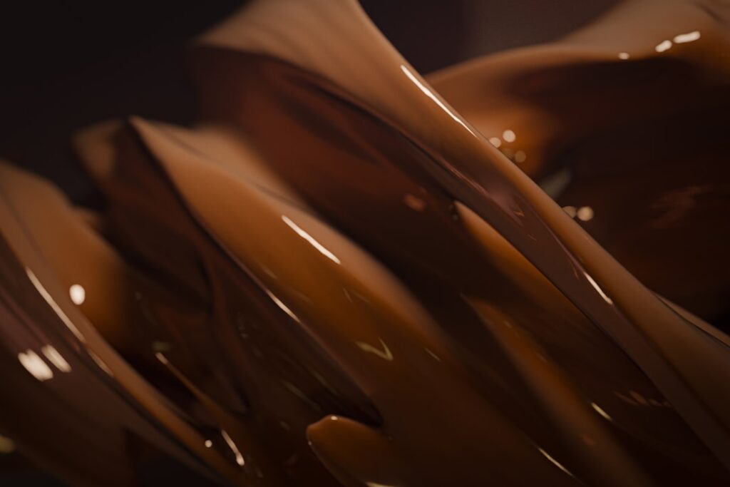 Glossy flowing chocolate swirls showing the smooth liquid texture of cocoa butter at work