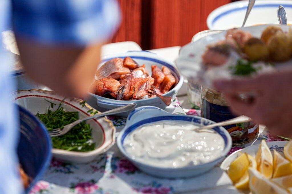 A traditional Swedish Midsummer outdoor lunch spread with herring, potatoes, cream sauce and side dishes